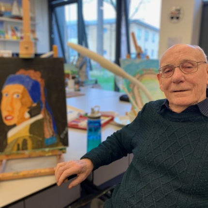 Veteran in Hawkhead Centre art room sat next to one of his paintings