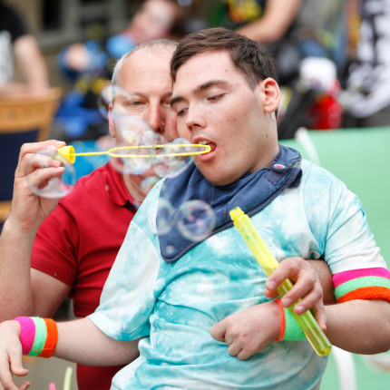 A young man who stays at Forward Vision blows bubbles