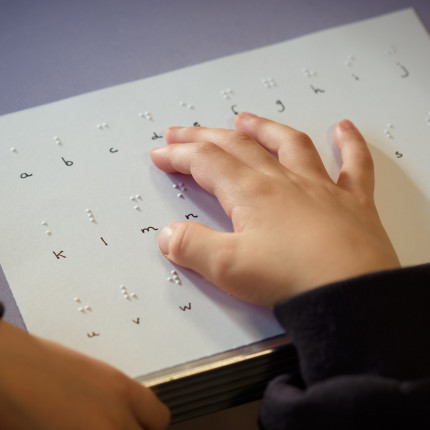 A Royal Blind School pupil reads a braille card