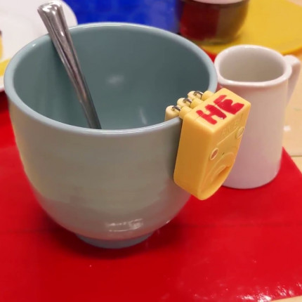 A cup with a device attached to alert the user when the liquid level has reached an appropriate point