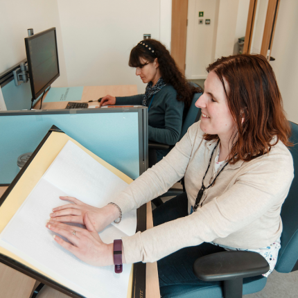 Scottish Braille Press staff member reads a braille document