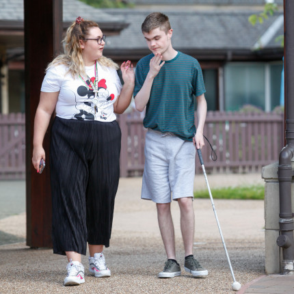 Ciaran, a young man who stays at the Allermuir residential unit, uses a white cane