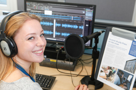 Scottish Braille Press employee records audio content in a booth
