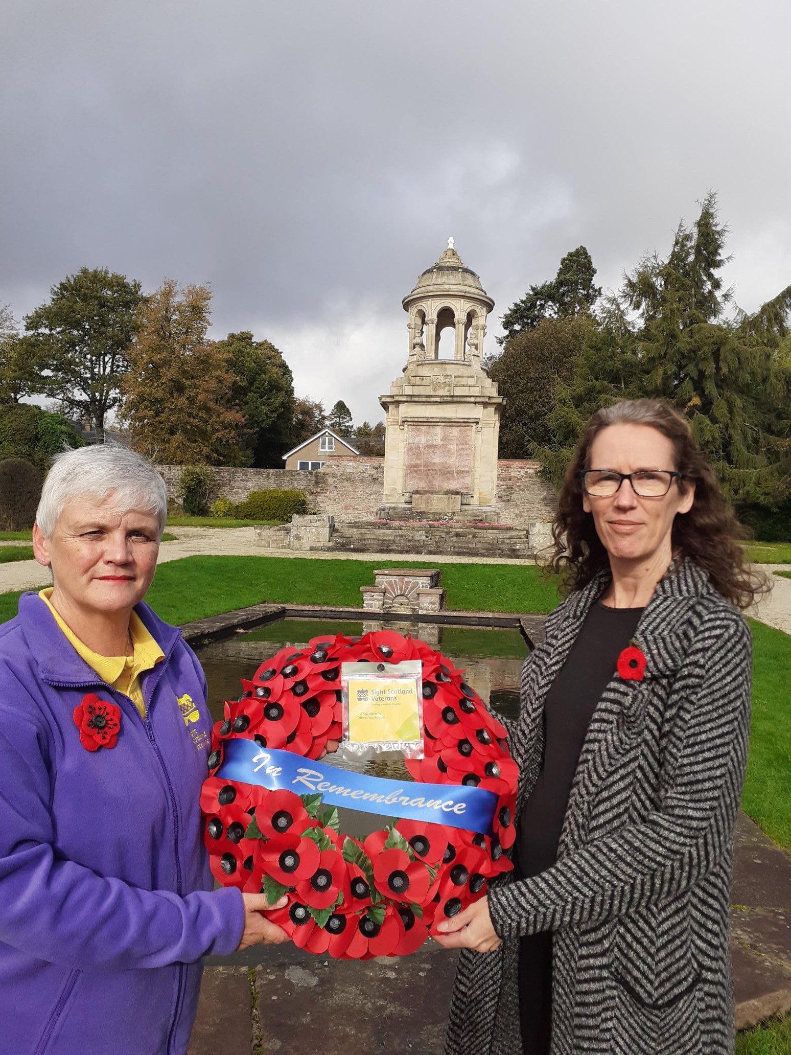 Outreach Workers Allison West and Gail Pringle holding a poppy wreath together in front of the Helensburgh War Memorial Outreach Workers Allison West and Gail Pringle holding a poppy wreath together in front of the Helensburgh War Memorial
