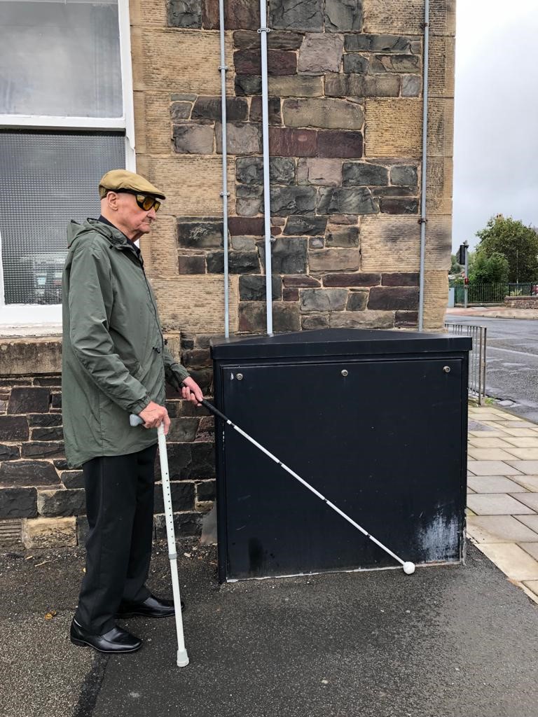 Veteran David Murray walks along the street with his long cane