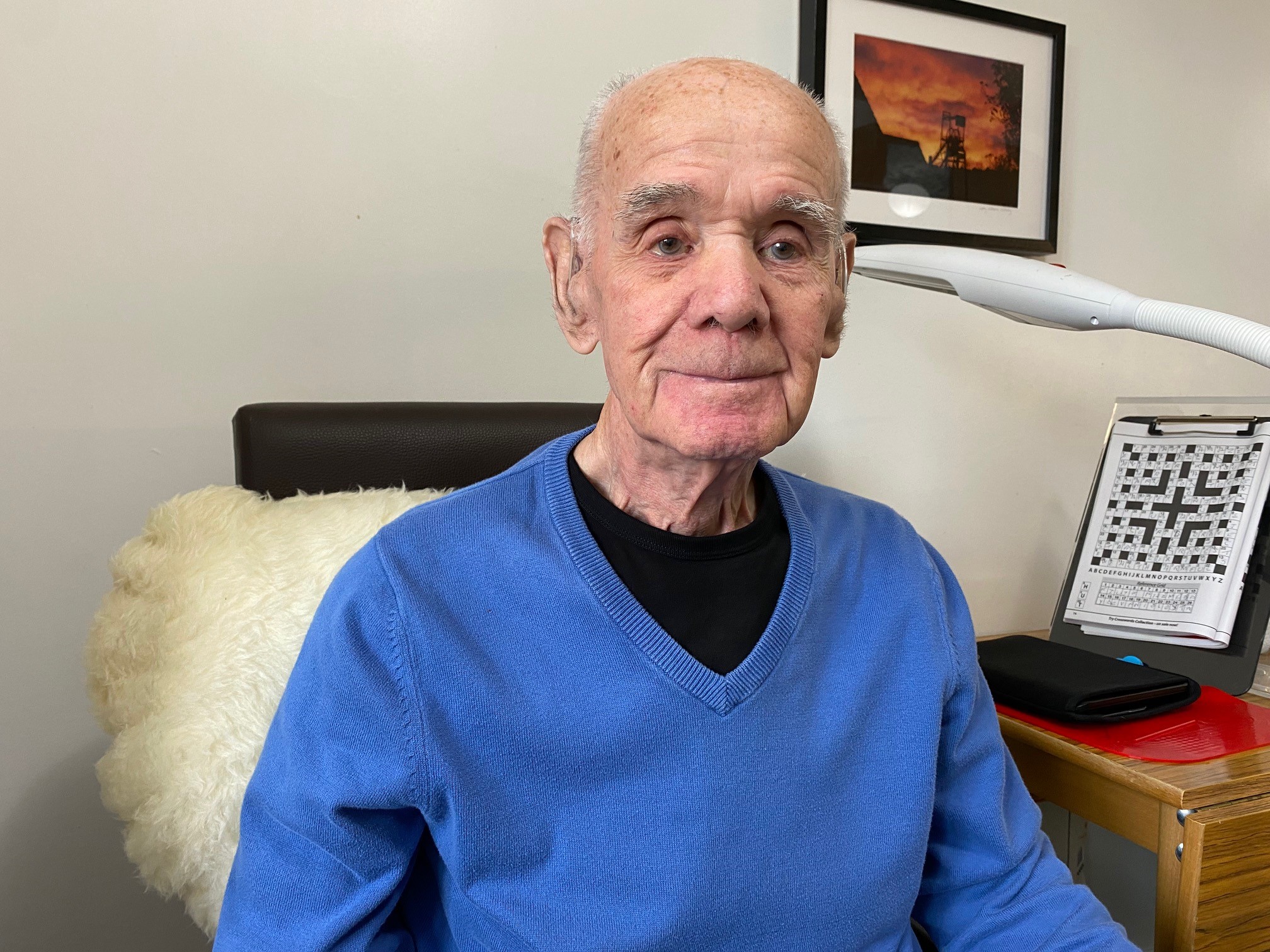 SSV veteran Henry Tyrell wearing a blue jumper sitting in front of his Code Words puzzle magazine