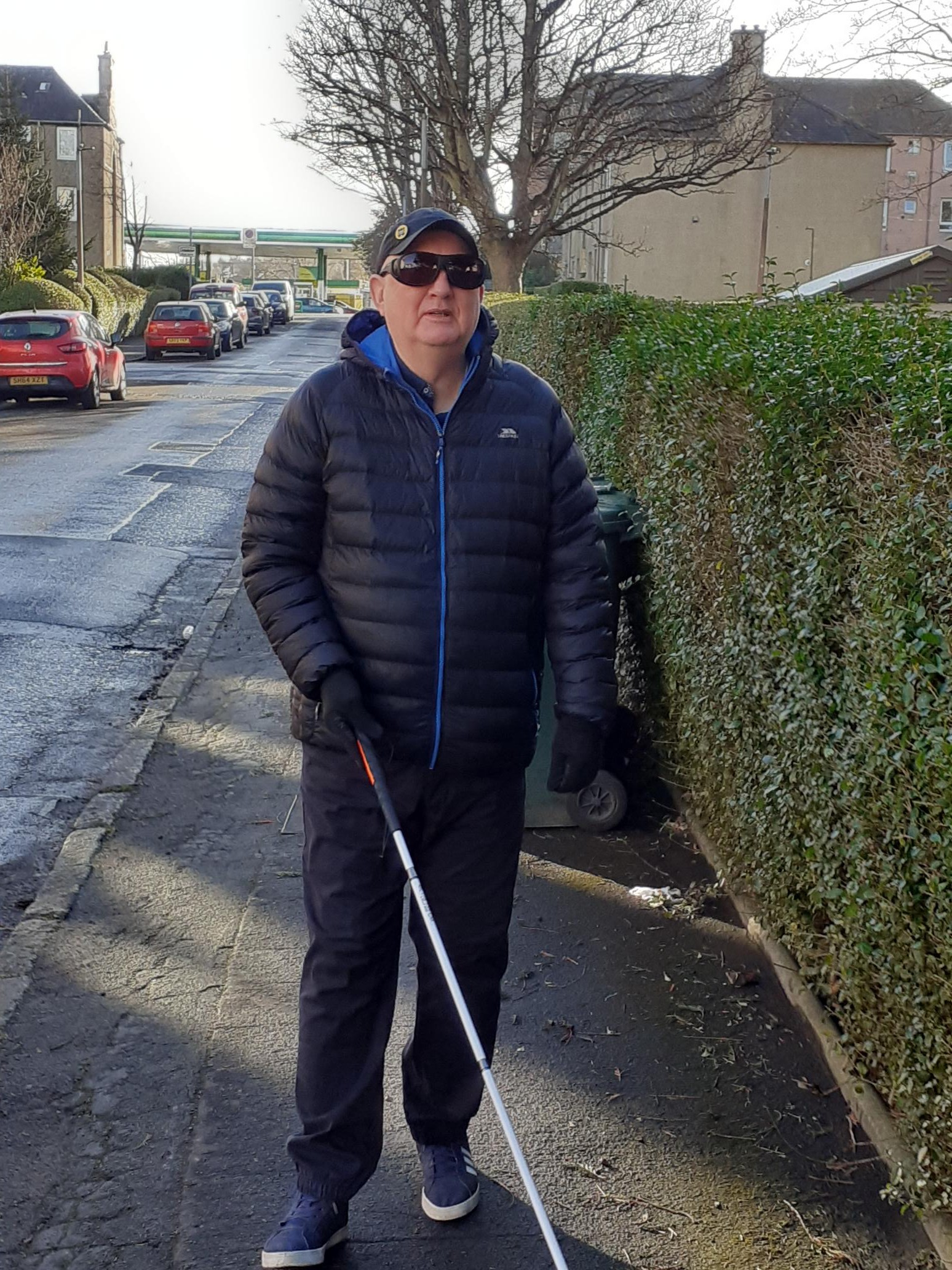 Veteran Stephen Jennings with long cane Veteran Stephen Jennings stands on the pavement holding a long cane out in front of him