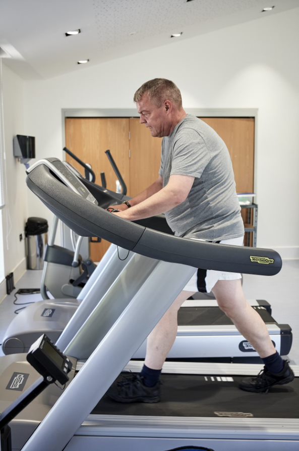 Man in gym using treadmill