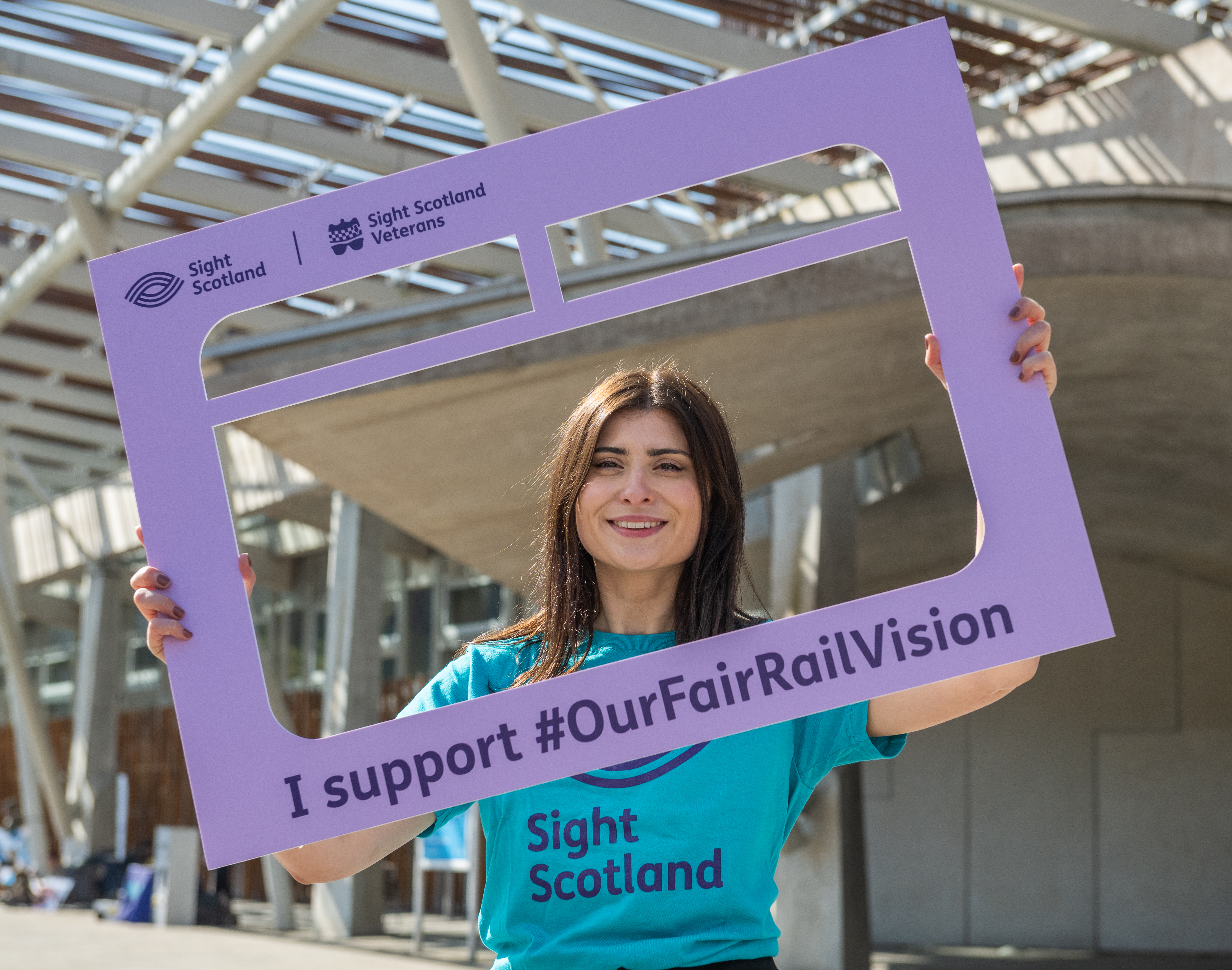 Sight scotland our fair rail vision activity at scottish parliament team member holding campaign sign