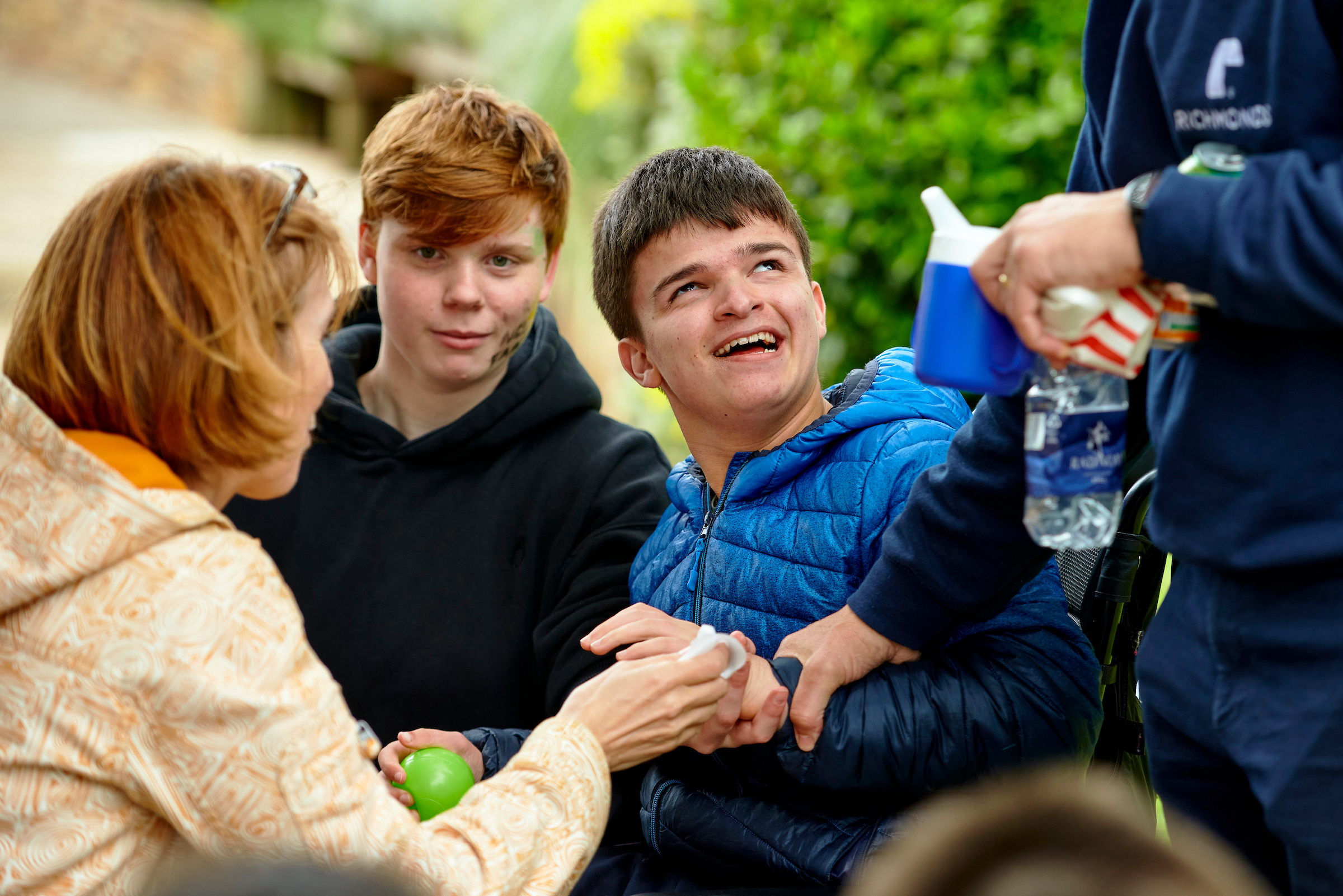 Three people outside looking and talking to one another.