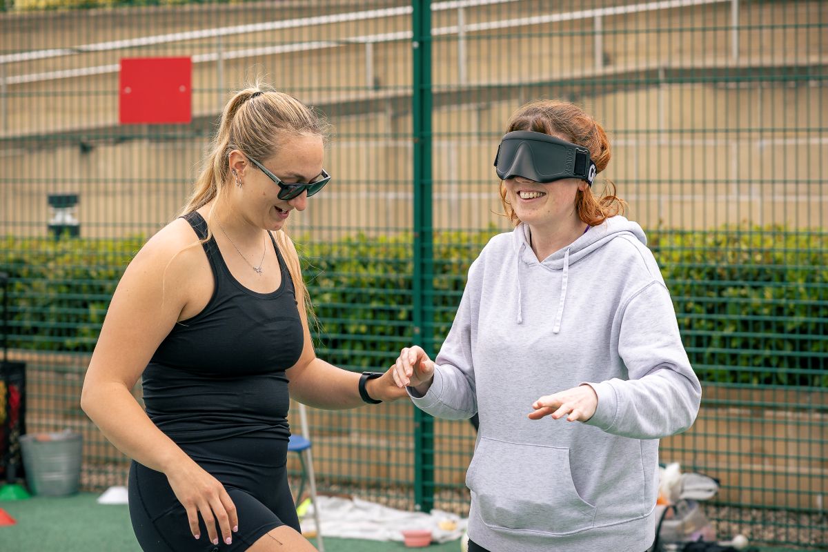 Former pupil and athlete, Sam Gough MBE, shows some of the students how to play blind football.
