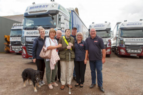 Charles surrounded by David Murray Staff and Carole Martin in front of HGVs