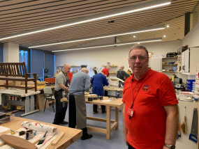 David in the Hawkhead Centre workshop with veterans working on projects behind him