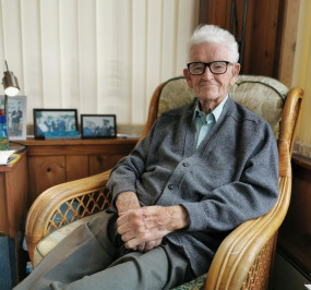 David Craig, age 94, sits smiling in a chair