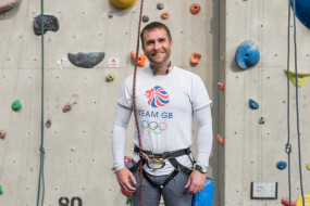 Garry Cowan stands in front of a climber