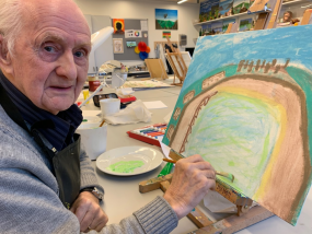 John painting at his easel in the Hawkhead Centre art room