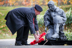 Veteran Toby Falconer lays the poppy wreath at the Hawkhead Centre's Tommy statue