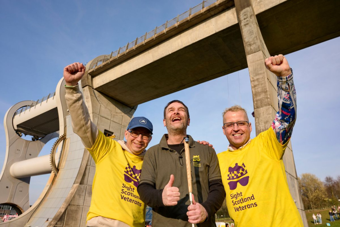Sight Scotland Veterans colleagues wearing branded t-shirts in front of the Falkirk Wheel