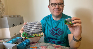 Fundraiser Stewart Lamb Cromar wears Lego t-shirt and holds Lego Main Library builds