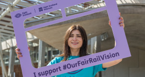 Sight scotland our fair rail vision activity at scottish parliament team member holding campaign sign