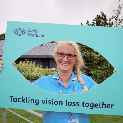 Care home colleague holding up a Sight Scotland selfie sign